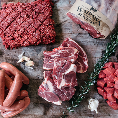Overview shot of different mat products. Diced beef, sausages, steaks and a leg roast.